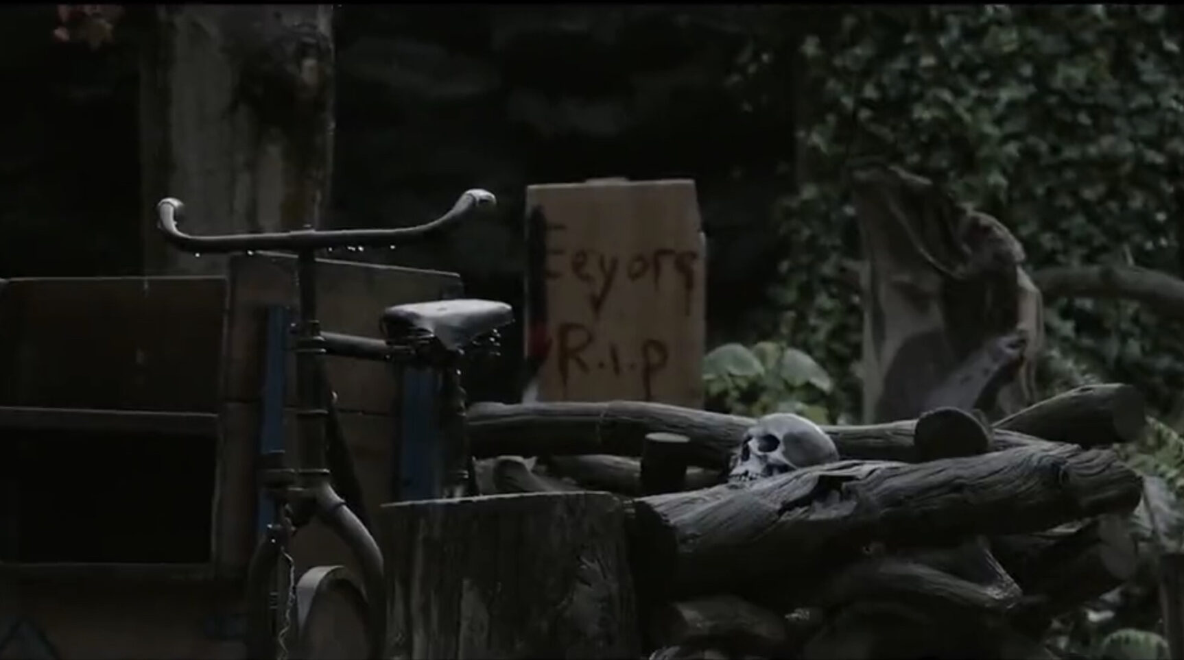 A cardboard sign reads Eyor RIP