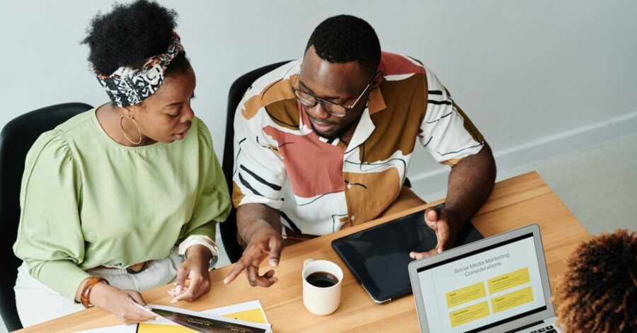 coworkers sitting at table working together on a project