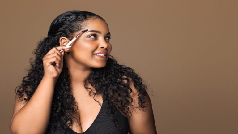 African American woman showing tips for perfect eyebrows