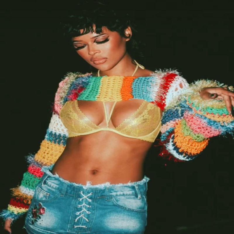 Serayah wearing a cut off crochet sweater and mini skirt