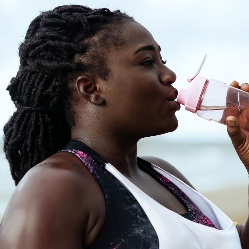 Woman drinking water on the beach