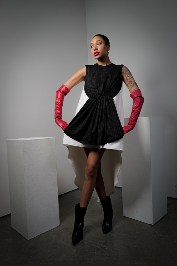 NYFW Model is wearing a black and white dress with red gloves to their elbows and black closed toe heels.