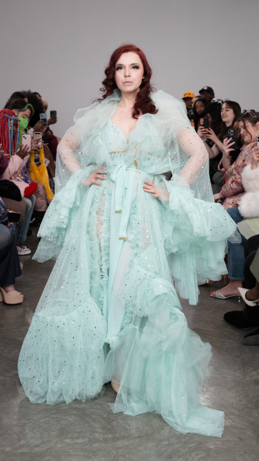 NYFW Turquoise robe with dramatic tulle. Model has deep red hair and is posing at the bottom of the runway.