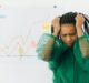 woman in green and white polka dot shirt covering her face